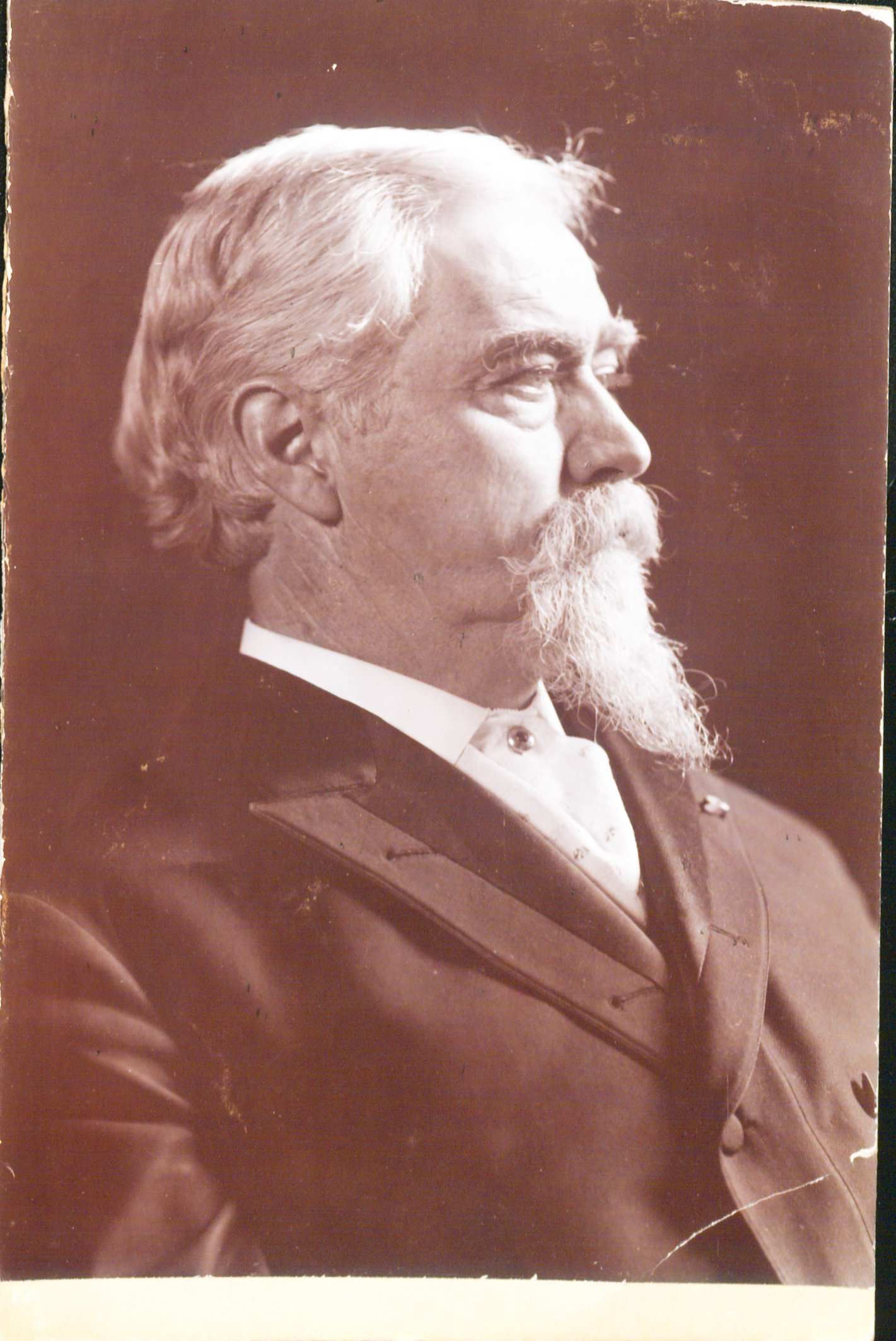 Portrait of John Black lookin off to the right. He has short hair a moustache and a beard