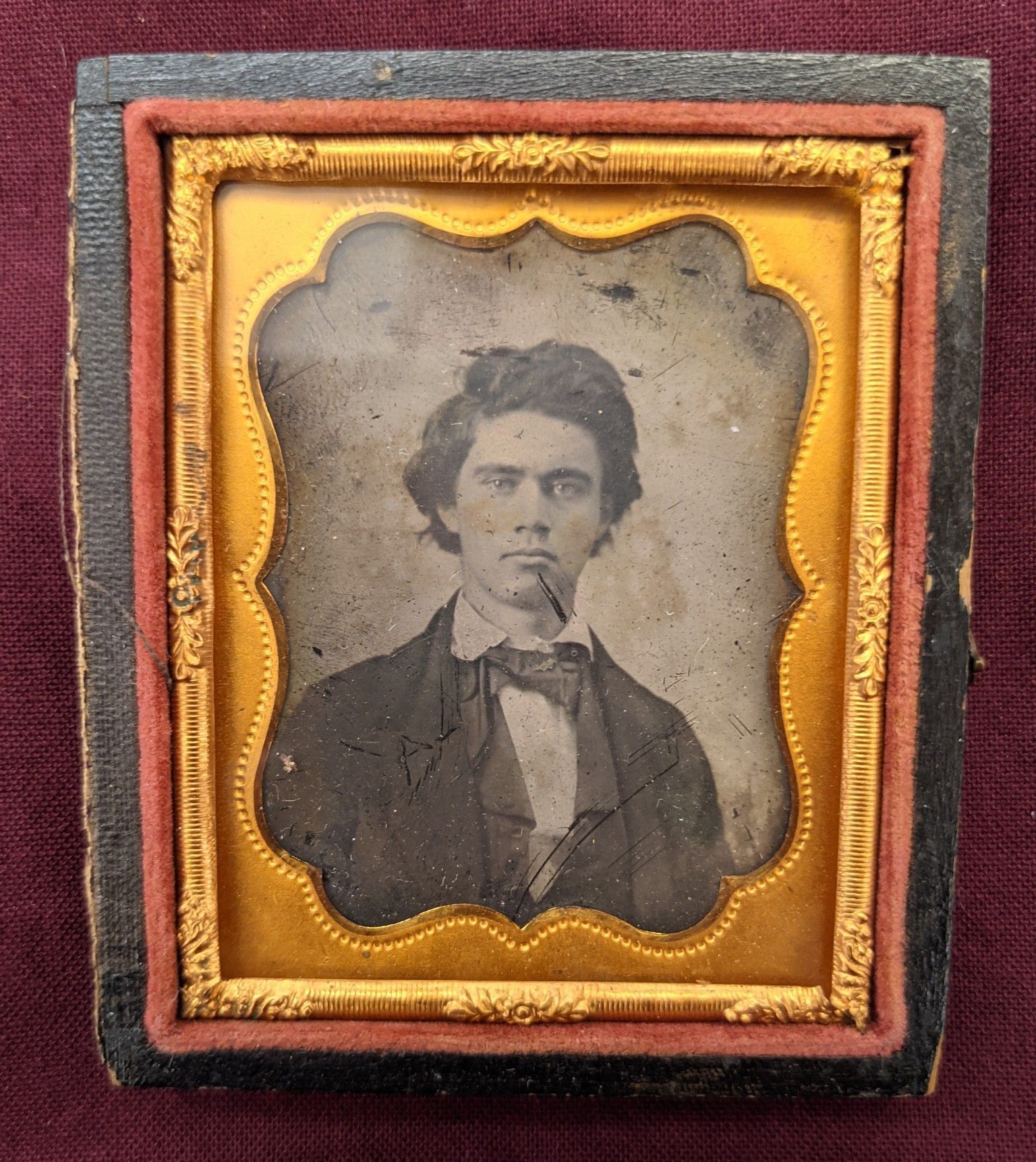 Portrait of a younger John Black inside a gold frame. He has a full set of hair and is wearing a 3 piece suit