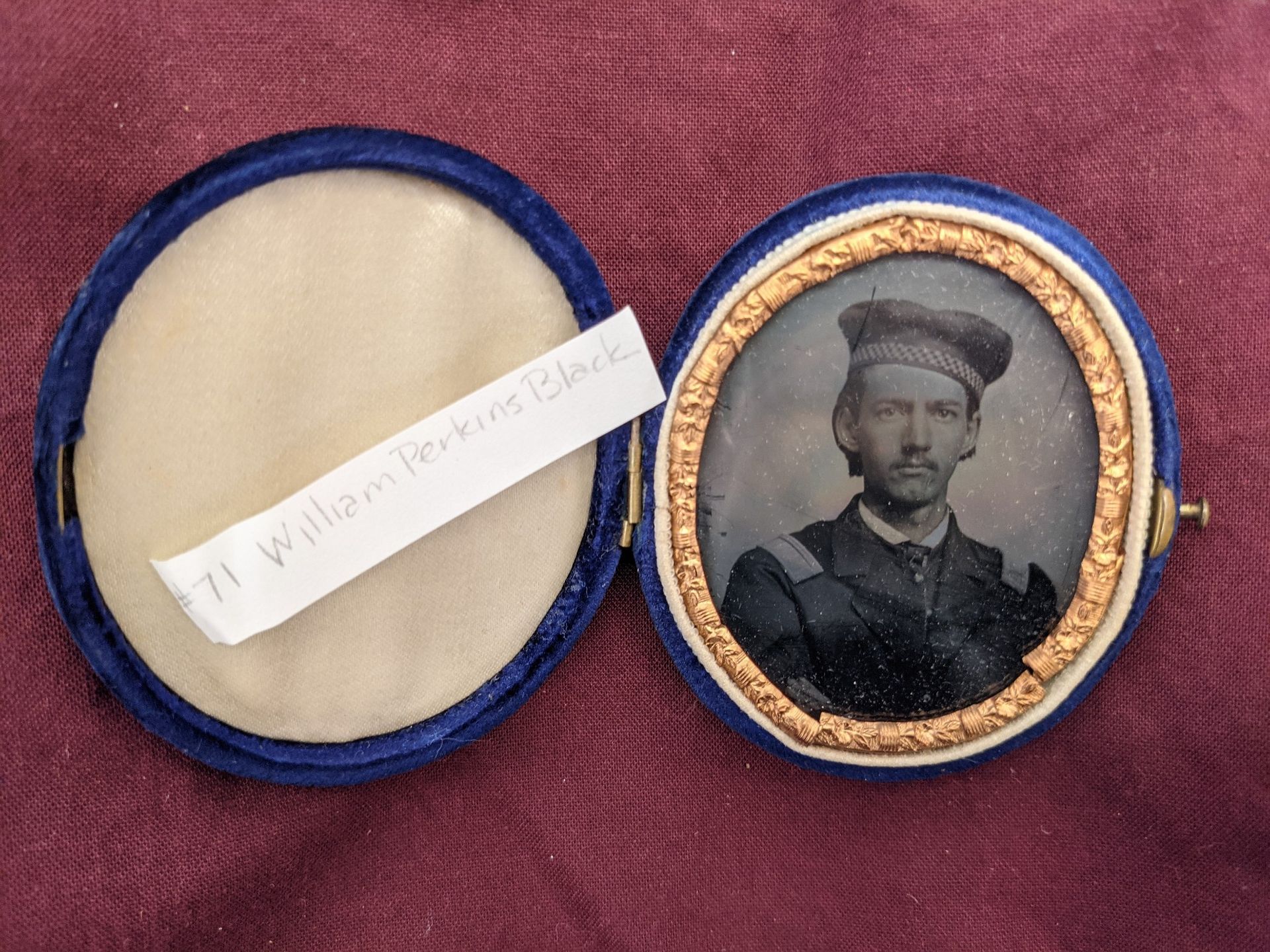A picture of a locket. There is a picture of William Black in military uniform on one side of the locket