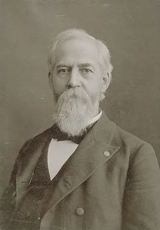 Portrait of William Perkins Black. He is facing forward with a beard. He is wearing a three piece suit with a bowtie.