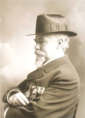 Left Profile View of John Charles Black with his arms crossed. He is wearing a hat, has a beard and there are meals of honor on his left breast pocket